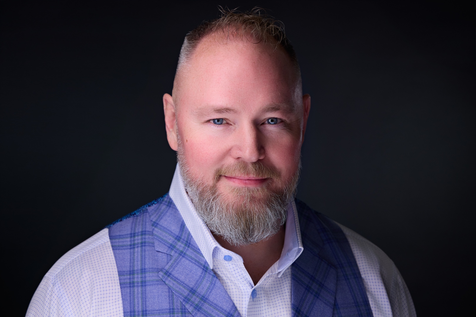 Studio color headshot of Jay Aldebert in a blue plaid vest